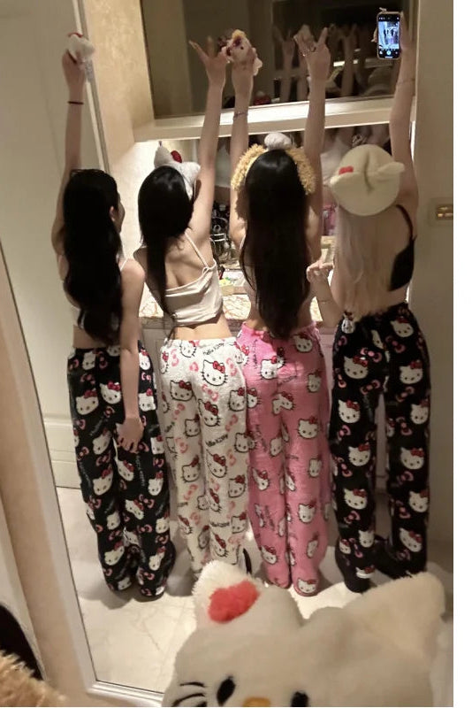 Four women in pajama pants with cartoon patterns taking a mirror selfie.